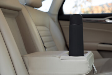 Black thermos in holder inside of car