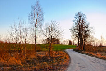 rural landscape, winding road and field in the evening at sunset