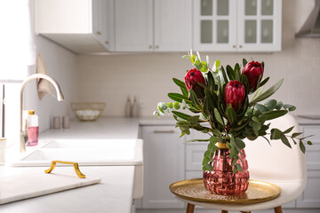 Bouquet with beautiful protea flowers in kitchen, space for text. Interior design