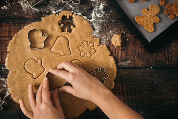 Making gingerbread christmas cookies on wooden background