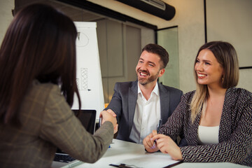 Successful businessman shaking hands with female client