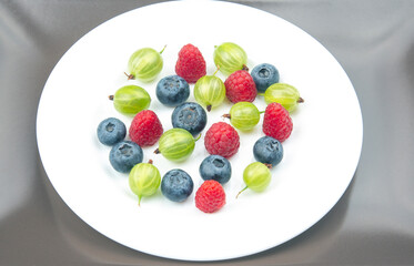 fresh different berries on a white plate. useful vitamin healthy food fruit. healthy vegetable breakfast