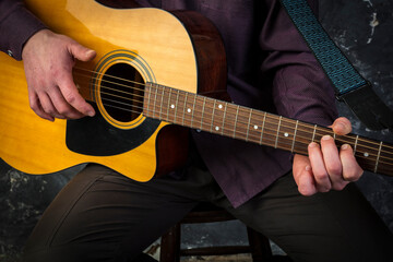 Fototapeta na wymiar Mature musician plays acoustic guitar emotional studio portrait.