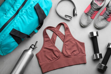 Flat lay composition with gym bag and sportswear on grey table