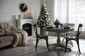 Festive table setting and beautiful Christmas decor in living room. Interior design