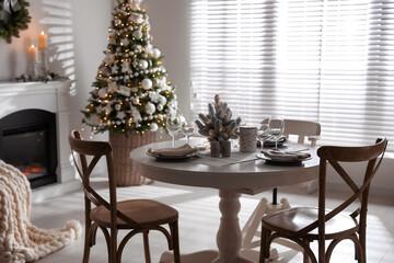 Festive table setting and beautiful Christmas decor in living room. Interior design