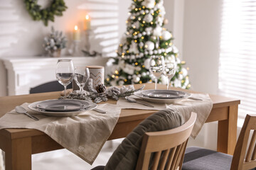 Festive table setting and beautiful Christmas decor in living room. Interior design