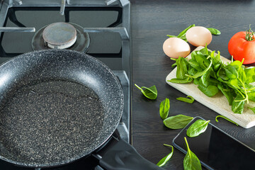 Food products: tomato, spinach leaves, eggs. Preparing food according to a recipe from the Internet. Cooking at home. Homemade food.