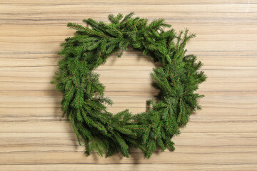 Christmas wreath made of fir branches on wooden background