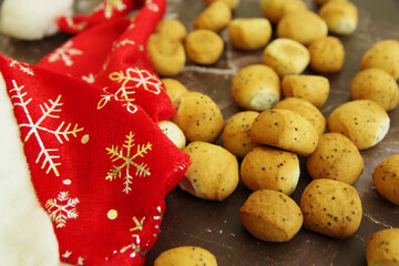 Christmas cookies Kuciukai and Santa Claus red hat isolated on a brown background. Kuciukai is a...