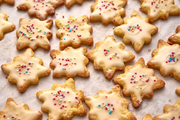 Biscuits Coated With Sugar Icing With Decorative Color Balls On A Sheet Of White Baking Paper