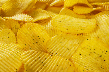 Potato fluted chips with spices, natural product close-up. Delicious background. Text on top of the image.