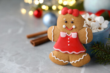 Gingerbread girl on grey marble table, closeup. Space for text