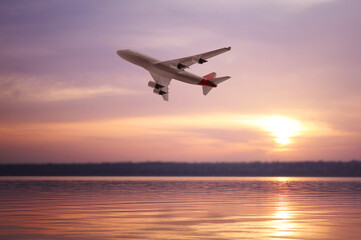 Fototapeta na wymiar Modern airplane flying over river during sunset