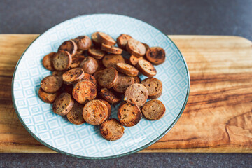 plant-based food, vegan sausage cut into salami slices and pan fried with cracked pepper on top