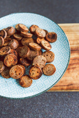 plant-based food, vegan sausage cut into salami slices and pan fried with cracked pepper on top