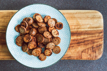 plant-based food, vegan sausage cut into salami slices and pan fried with cracked pepper on top