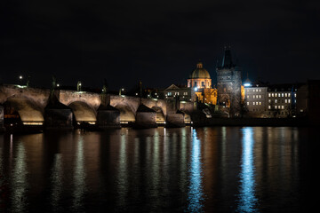 Fototapeta na wymiar .Charles Bridge and lights from street lights are reflected on the surface of the Vltava River in the center of Prague at night in the Czech Republic