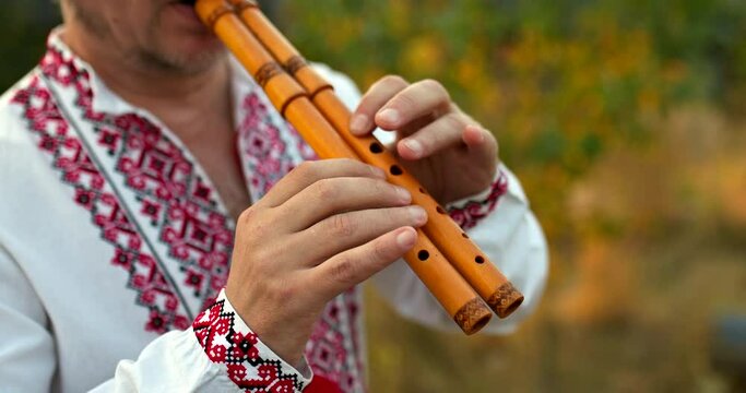 Close-up, fingers clamping holes in a wooden pipe. Folk musical instruments, playing on a double pipe. 4k, ProRes