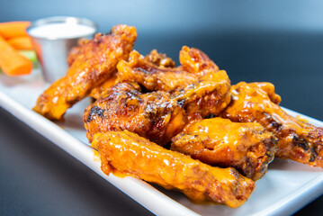 Delicious sweet spicy chicken wings piled on a plate makes the mouth water and the stomach growl.