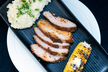 Overhead view of delicious creole crusted turkey breast with mashed potatoes and corn on the cobb makes the mouth water and the stomach growl.