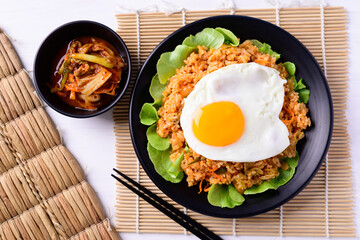 Korean food, Kimchi fried rice with fried egg on top and fresh kimchi cabbage, Top view