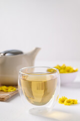Organic Chrysanthemum flower tea in a cup and teapot on white background, Healthy Herbal drink