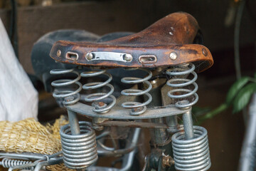 Brown leather saddle of bicycle with springs