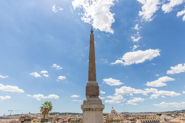 Sallustiano Obelisk against blue sky above Spanish Steps, in front of The church of the Santissima...