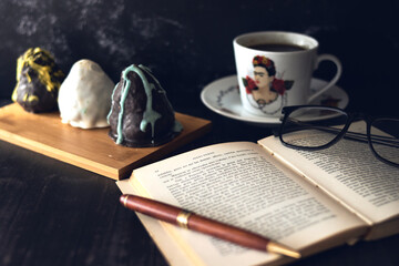 Reading a book with black coffee and cakes
