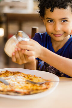 Happy African American Kid Eating Pizza.