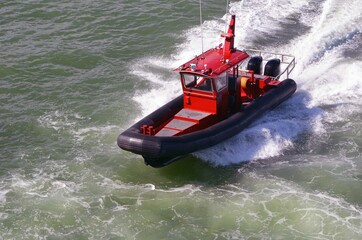 Obraz premium Tow Boat racing to assist a recreational boat in distress.