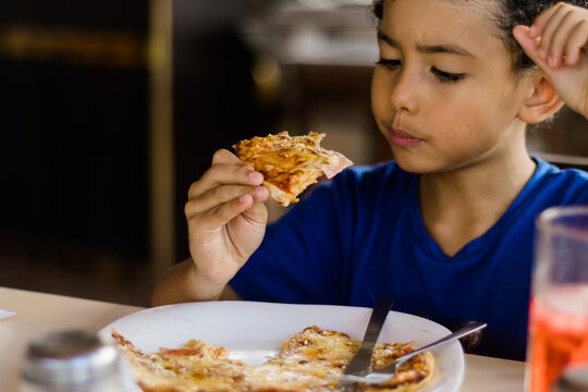 Happy African American Kid Eating Pizza.