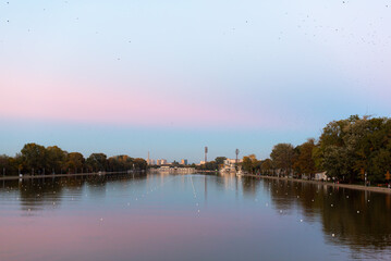 Vibrant blue and pink sunset over rowing canal with water reflections of trees in Plovdiv, Bulgaria