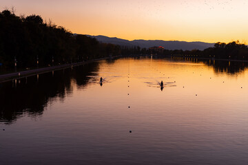 Kayaks racing in canal water reservoir for rowing sport practice on sunset vibrant background in Plovdiv, Bulgaria © Valentin