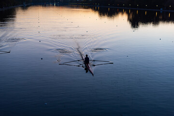 Kayaks racing in canal water reservoir for rowing sport practice on sunset vibrant background in Plovdiv, Bulgaria