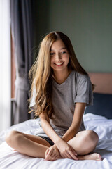 Obraz premium Beautiful long hair women sitting on the bed. 