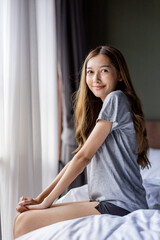 Naklejka premium Beautiful long hair women sitting on the bed. 