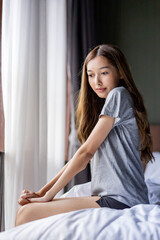 Naklejka premium Beautiful long hair women sitting on the bed. 