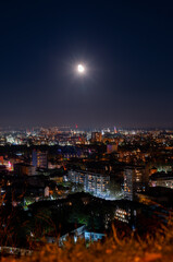 Big dark city lit up by moonlight and thousands of small lights high point view from hill peak of Plovdiv, Bulgaria