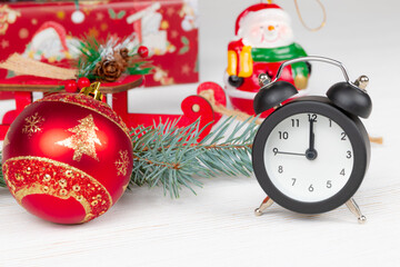 santa claus sleigh, gift boxes, spruce branch, alarm clock and snowman on wooden white background