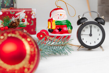 santa claus sleigh, gift boxes, spruce branch, alarm clock and snowman on wooden white background