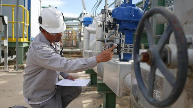 Technicians in the factory on a daily basis and recorded in documents for inspection on the clipboard, Petroleum Oil and refinery concept,

