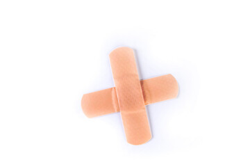 Two pieces of colored bandage strips forming a plus medical sign top down view