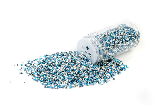 White blue and black sprinkles heaping amount spilled from a container with a shaker lid