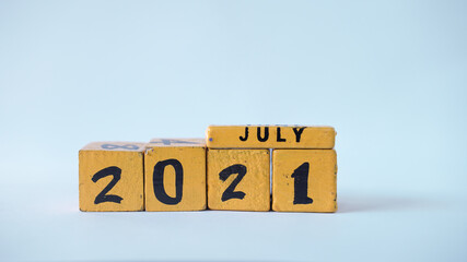 Wooden block calendar with a focus on July 2021. White background