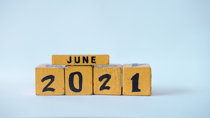Wooden block calendar with a focus on June 2021. White background