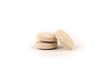 Fototapeta na wymiar Three yellow and brown flecked stacked chewable dog multivitamin isolated over white