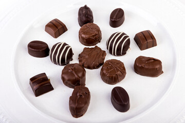 White plate filled with molded chocolates isolated over white