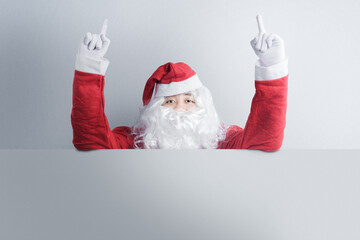 Asian man in Santa costume showing an empty board
